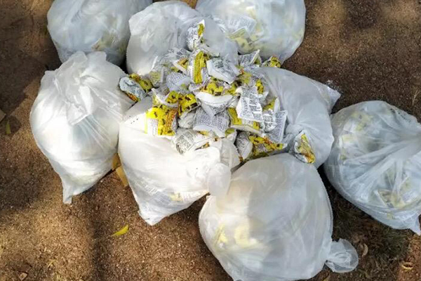 ග්ලයිෆොසේට් අඩංගු රසායනික ද්‍රව්‍ය තොගයක් සමඟ පුද්ගලයෙක් අත්අඩංගුවට